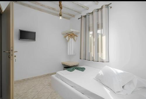 Habitación blanca con cama y ventana en Cozy Andrée Apartment, en Pachaina
