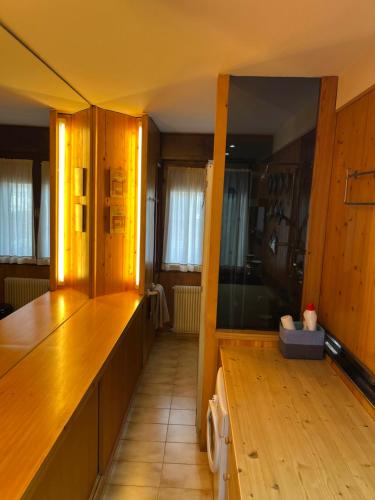 a kitchen with wooden cabinets and a wooden floor at APPARTAMENTO FORTUNA GIANNA in Fiera di Primiero