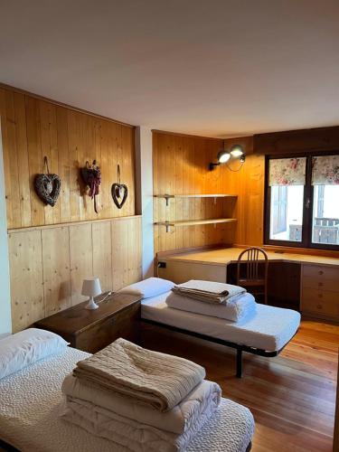 two beds in a room with wooden walls at APPARTAMENTO FORTUNA GIANNA in Fiera di Primiero