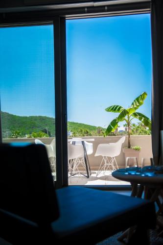a room with a view of a table and chairs at Soleil Village & Villas in Jal