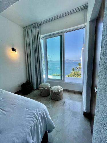 een slaapkamer met een bed en een groot raam bij Luxurious residence with sea view in Manzanillo