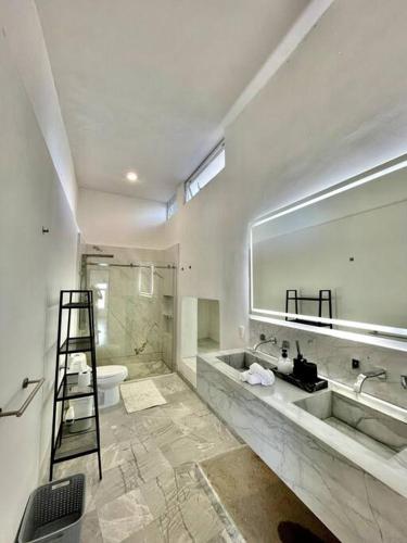 een badkamer met een grote spiegel en een wastafel bij Luxurious residence with sea view in Manzanillo