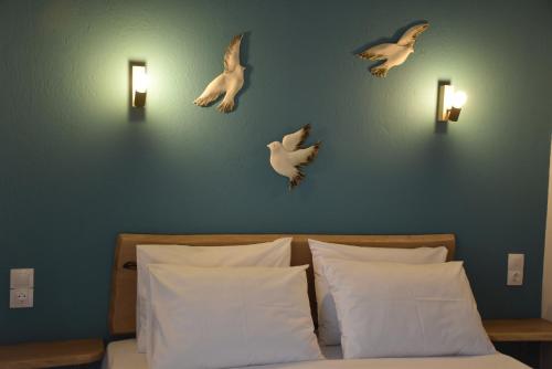 un dormitorio con pájaros volando sobre una cama en ARELIA APARTMENTS IERISSOS, en Ierissos