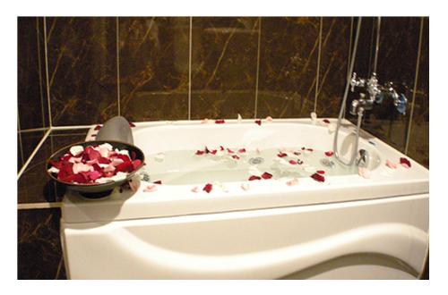 a bath tub with a bowl of roses on it at Fu Chia Hotel in Keelung