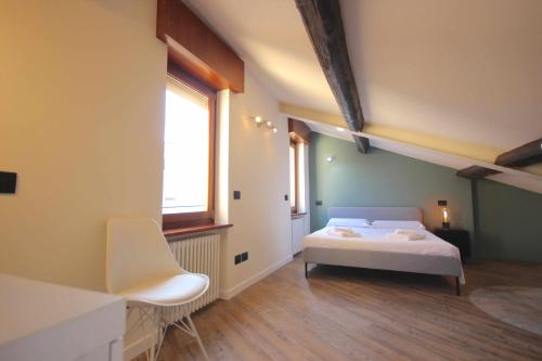 um quarto com uma cama branca e uma janela em Case VR Holiday Vittorias Flat em Verona