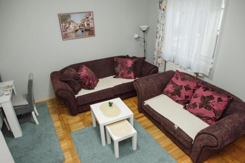 a living room with two couches and a table at ĐILL 2 APARTMANTS in Subotica
