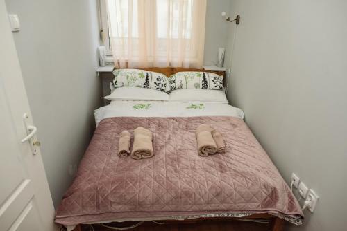 a small bedroom with a bed with shoes on it at ĐILL 2 APARTMANTS in Subotica