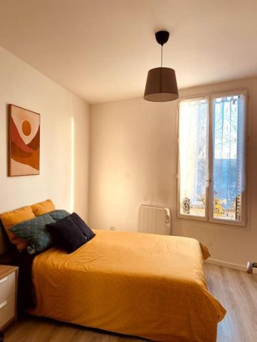 een slaapkamer met een groot geel bed en een raam bij Proche Paris-Calme-Wifi-Netflix in Villejuif