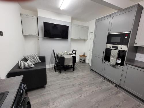 a living room with a table and a kitchen at La Casa Bella in Sheffield