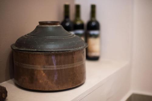 two bottles of wine sitting on a counter with a pot at Papa-Antonis Stone House in Zarós