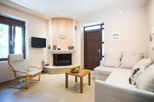 a living room with a couch and a fireplace at Papa-Antonis Stone House in Zarós