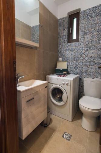 a bathroom with a washing machine and a washer at Papa-Antonis Stone House in Zarós