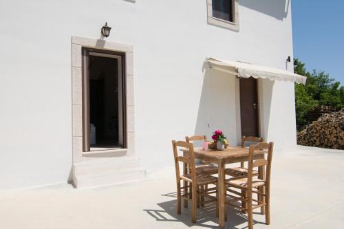 a small table and chairs on a patio at Papa-Antonis Stone House in Zarós