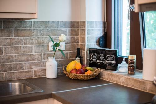 a kitchen counter with a bowl of fruit and a sink at Papa-Antonis Stone House in Zarós