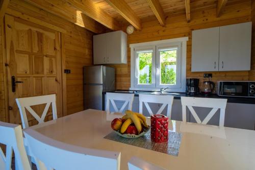 a kitchen with a table with a bowl of fruit on it at Perłowe Wzgórze in Ustronie Morskie