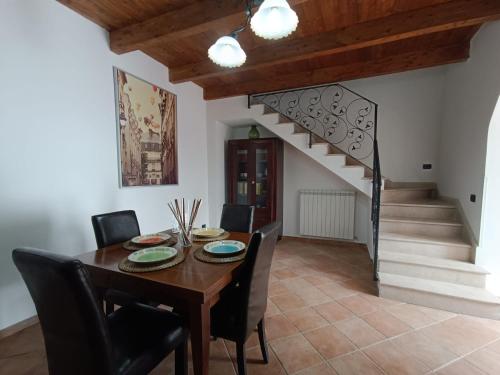 a dining room with a table and chairs and a staircase at Il Rifugio in Casertavecchia