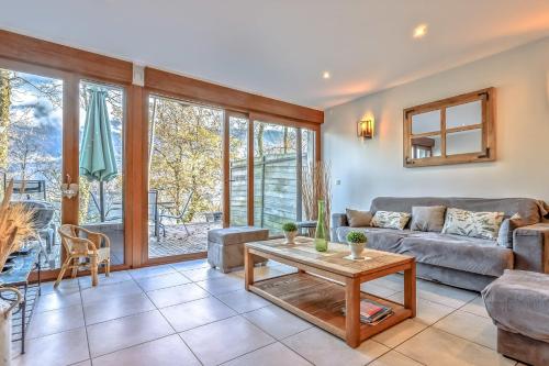 un salon avec un canapé et une table dans l'établissement Les Terrasses de Bredanne, à Doussard