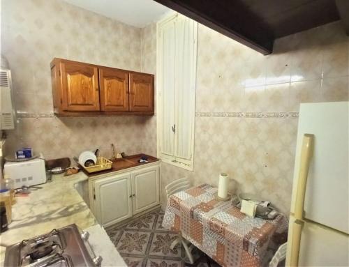 a kitchen with wooden cabinets and a table in it at Appart Central in Tunis