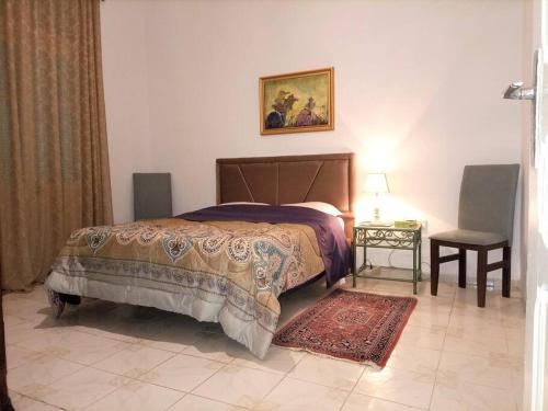 a bedroom with a bed and a table and a chair at Appart Central in Tunis