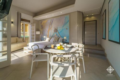 een woonkamer met een tafel en stoelen en een bed bij Matteotti Luxury Residence in Siracusa