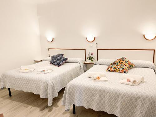a room with two beds with towels on them at Soggiorno Marina in Varazze