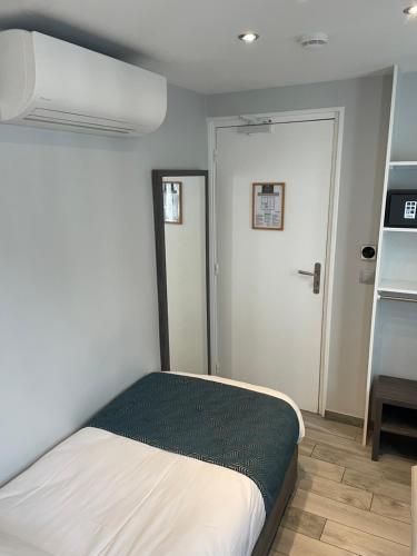 a small bedroom with a bed and a door at Mary's Hotel République in Paris