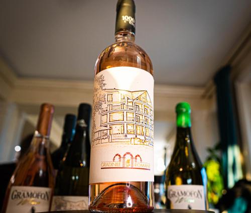 Gradinile Romane في Hangul: زجاجة من النبيذ موضوعة على طاولة مع زجاجات أخرى