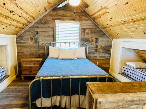 a bedroom with a bed in a room with wooden walls at Knotty Squirrel Cabins in Mountain View