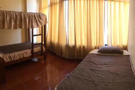 1 dormitorio con 2 literas y ventana en Hostal Huacachina Sunset, en Ica