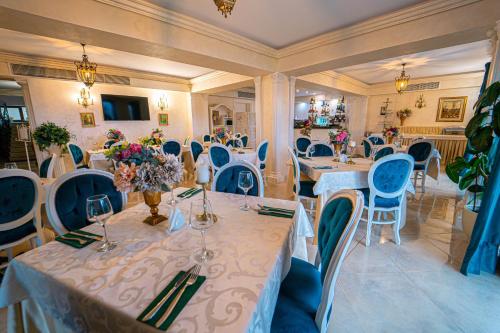 a dining room with tables and blue chairs at Gradinile Romane in Hangul