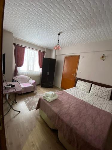 a bedroom with two beds and a table and a tv at Abant Barış Pansiyon in Dereceören