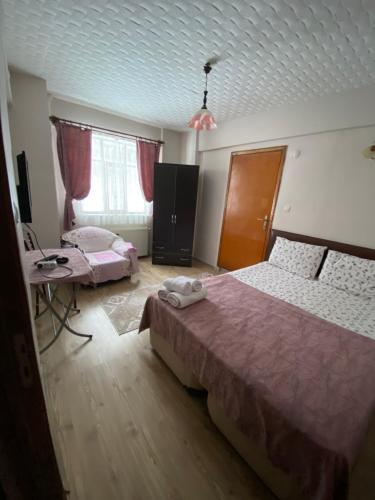 a bedroom with two beds and a table and a window at Abant Barış Pansiyon in Dereceören