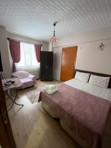 a bedroom with two beds and a table and two windows at Abant Barış Pansiyon in Dereceören