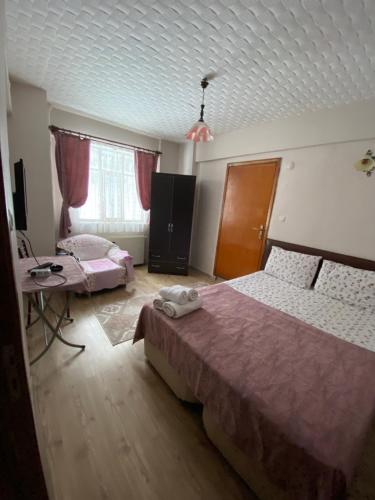 a bedroom with two beds and a table and a tv at Abant Barış Pansiyon in Dereceören