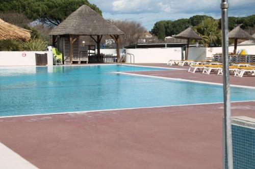 uma piscina com um campo de voleibol num resort em mobil home au lac des rêves em Lattes