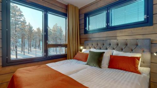 um quarto com uma cama grande e uma janela grande em Kurula's Resort em Pyhätunturi