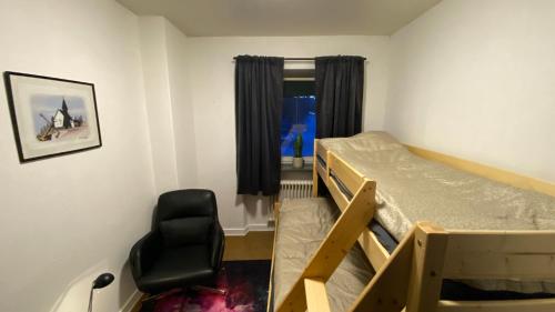 a bedroom with a bunk bed and a chair at Sjømannskirken Narvik in Narvik