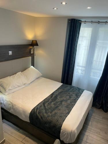 Schlafzimmer mit einem Bett und einem Fenster in der Unterkunft Mary's Hotel République in Paris