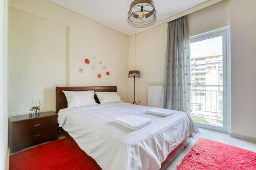 1 dormitorio con 1 cama blanca grande con alfombra roja en Escape with Style in this Chic 2BR Apartment!, en Atenas