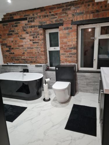 a bathroom with a bath tub and a toilet at Cosy Riverside home in Llanwrda