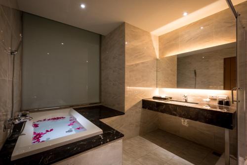 uma casa de banho com uma banheira e um lavatório em Chateau-Rich Hotel em Tainan