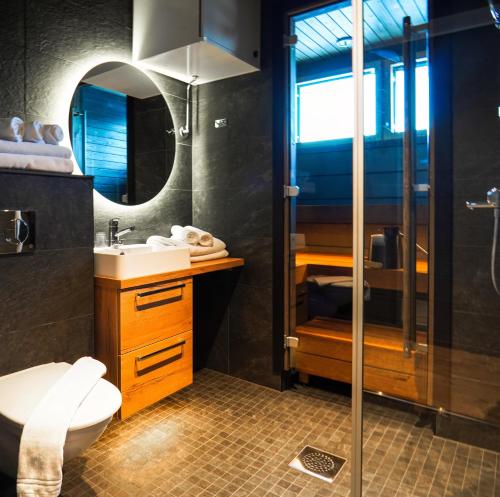 a bathroom with a sink and a toilet and a mirror at Kurula's Resort in Pyhätunturi