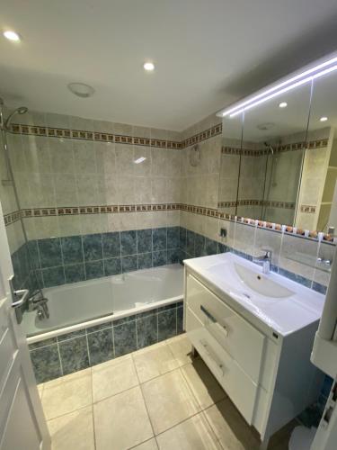 een badkamer met een bad, een wastafel en een bad bij Appartement VAIANA avec piscine en bord de mer in Ajaccio