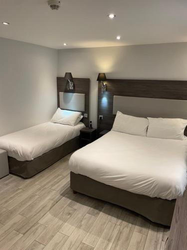 two beds in a hotel room with white sheets at Mary's Hotel République in Paris