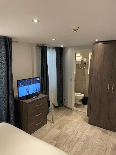 パリにあるメアリーズ　ホテル　レピュブリックのベッドルーム(ドレッサー内のテレビ付)、バスルーム