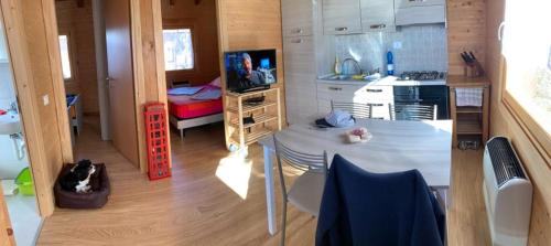 una pequeña cocina con mesa en una casa pequeña en Camping & Chalet Pian della Regina, en Cevo