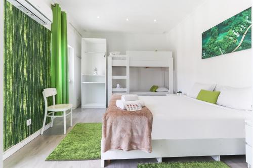 1 dormitorio con cama blanca y pared de acento verde en Downtown Lisbon Palma Suites by Homing, en Lisboa