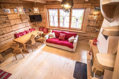 a living room with a red couch and a table at Wooden Tatra House in Zakopane