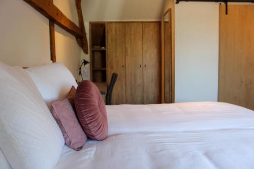 a bedroom with a white bed with two pillows at De Kasteelhoeve in Westmalle