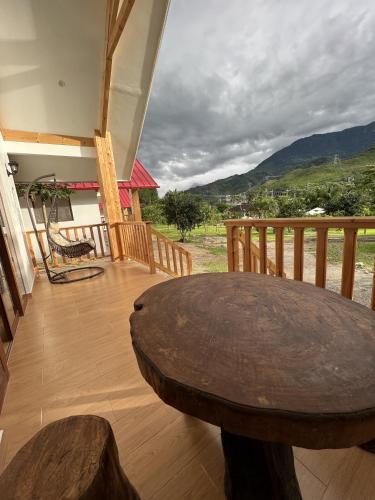 a wooden porch with a wooden table on a deck at Mercedes Lodge in San Ramón